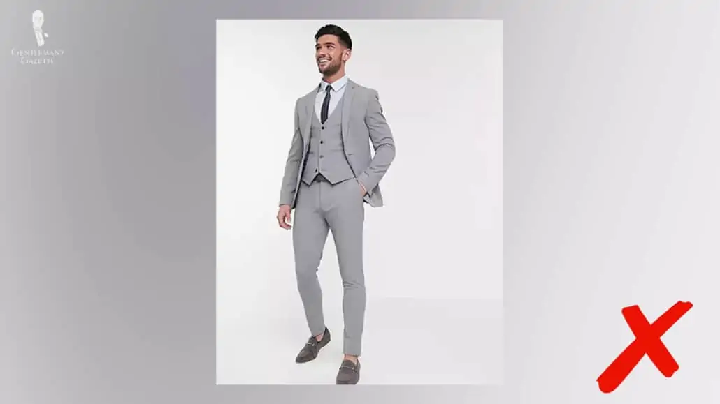 A man wearing a gray suit that is extremely slim cut