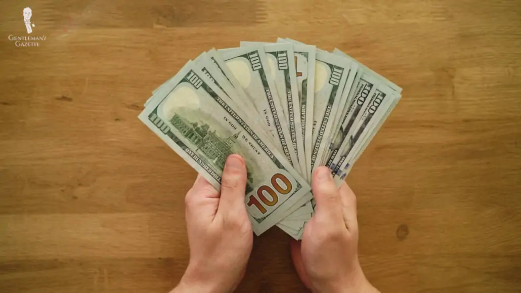 A pair of hands showing hundreds of dollars.