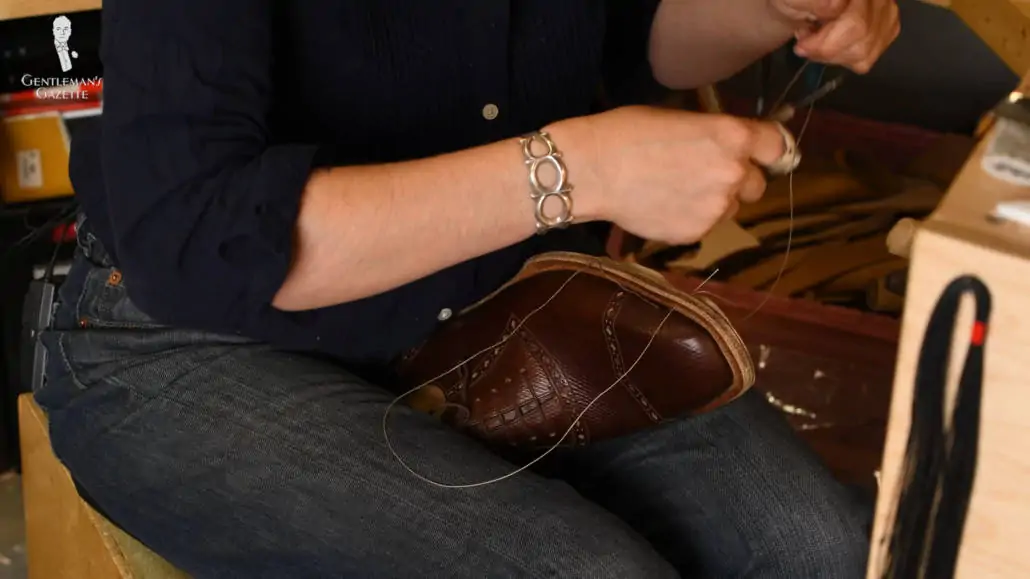 A skilled bespoke shoemaker hand-welting shoes.