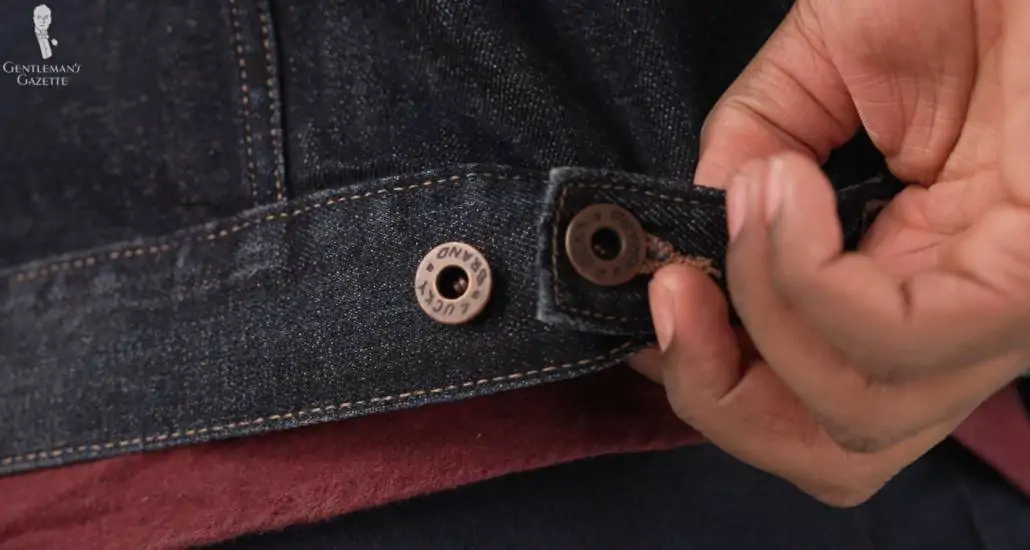 Kyle showing the high-quality fastening and stitching of his denim jacket up close