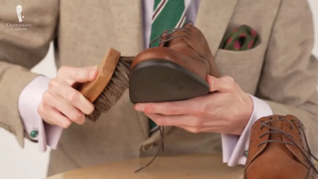 Preston brushing his brown Goodyear welted oxford shoes