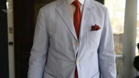 Raphael wearing a light blue seersucker suit with prominent wrinkles. 