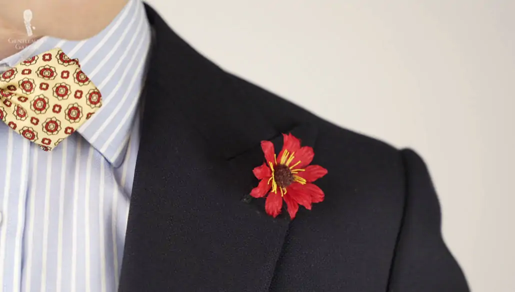 Red exotic caribbean boutonniere pinned in a navy suit jacket