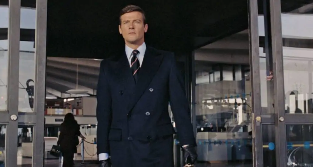 Roger Moore as James Bond in Live & Let Die, wearing a navy paletot.