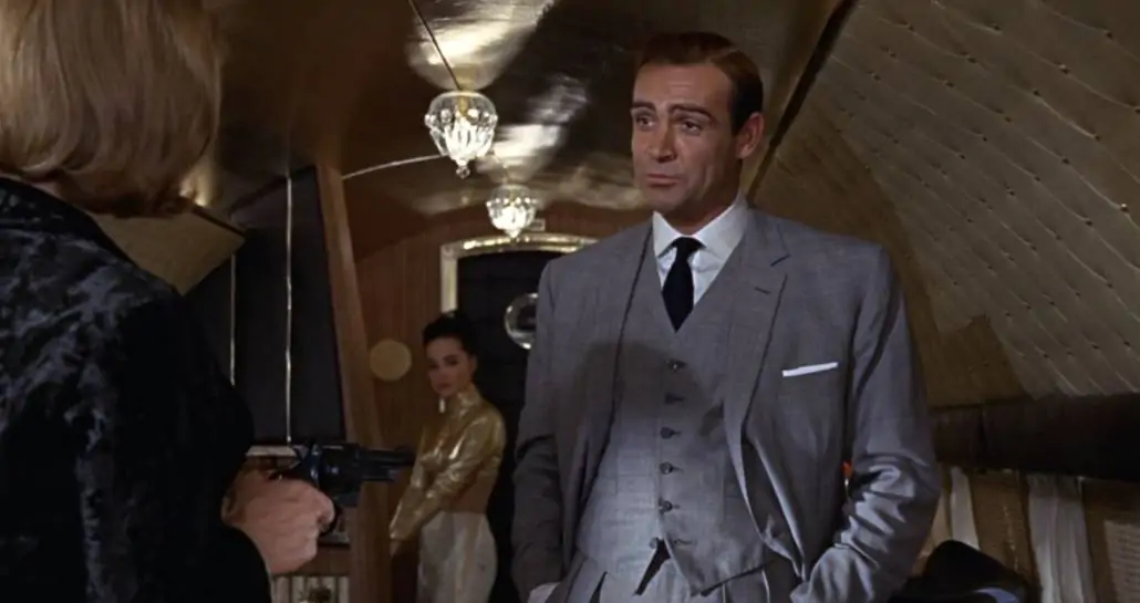 Bond wearing a a three-piece tropical wool suit in a muted color