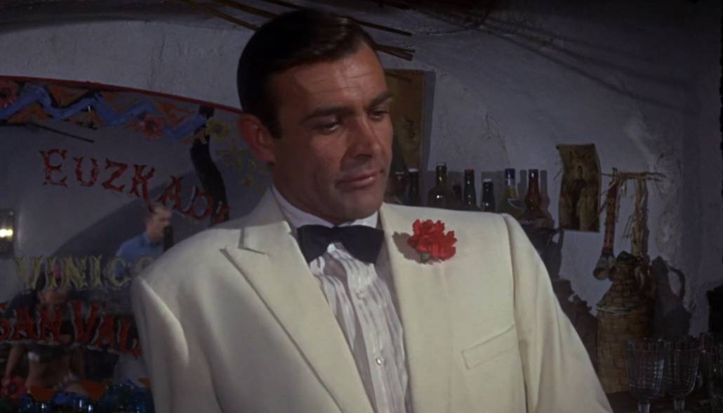 The red carnation boutonniere is a tasteful accent to this classic look.