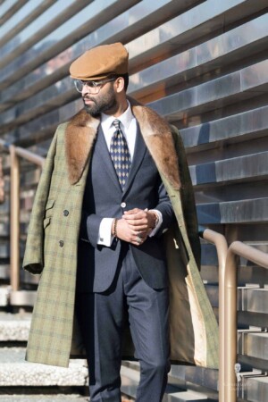 Gentleman with navy suit and green windowpane overcoat with fur lining