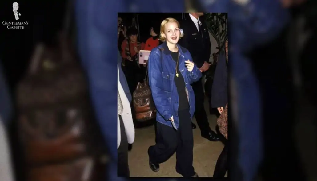 Drew Barrymore wearing an oversized denim jacket in the 90s