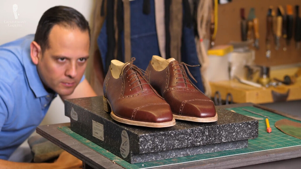 Raphael closely inspecting the details of his bespoke shoes.