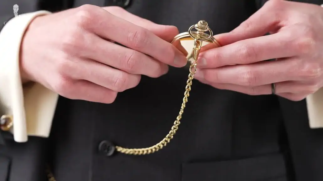 Preston's gold pocket watch and dark metallic wedding ring