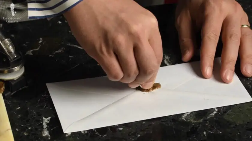 Raphael using his signet ring to wax-seal a letter