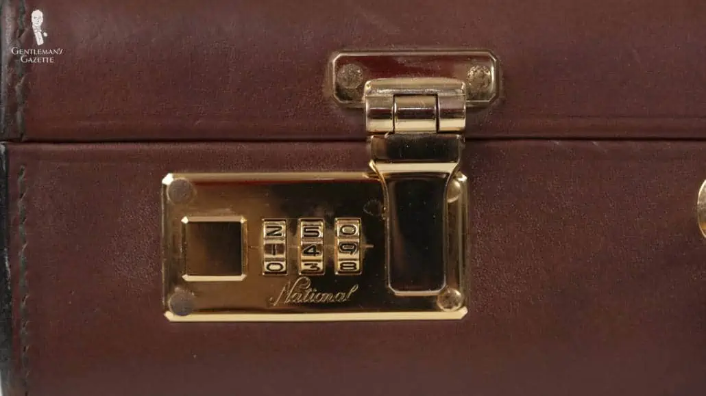 A brown attache case with combination locks.