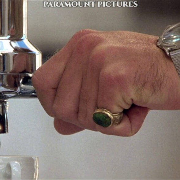 A close-up look at Dickie’s pinky ring with a green stone and his Swanson 30-meter quartz watch.