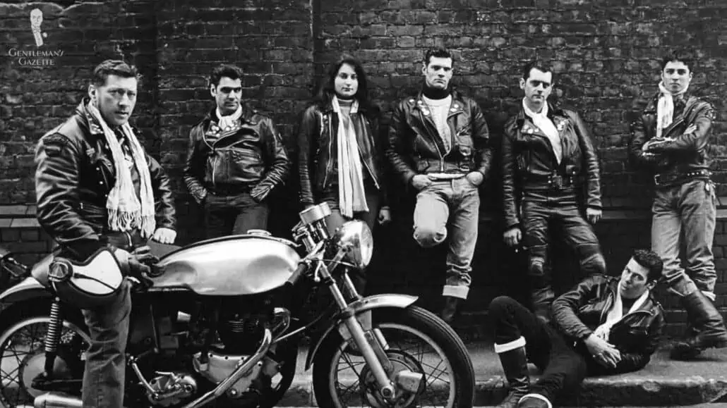 A group of men and a lady wearing greasers inspired outfits.