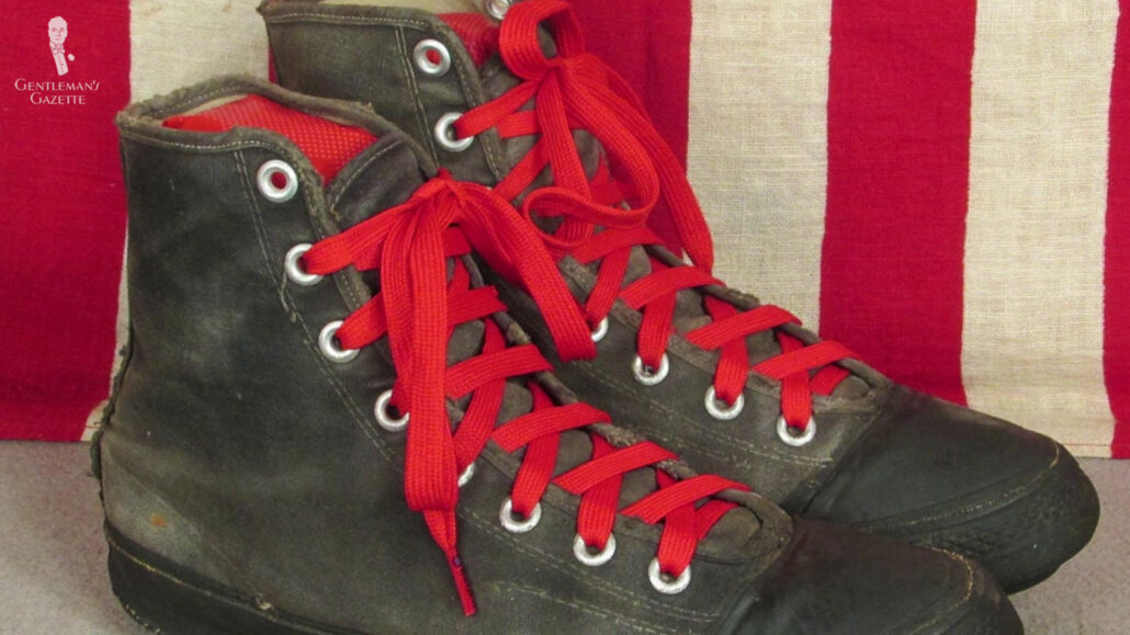 A pair of black converse shoes with red laces.