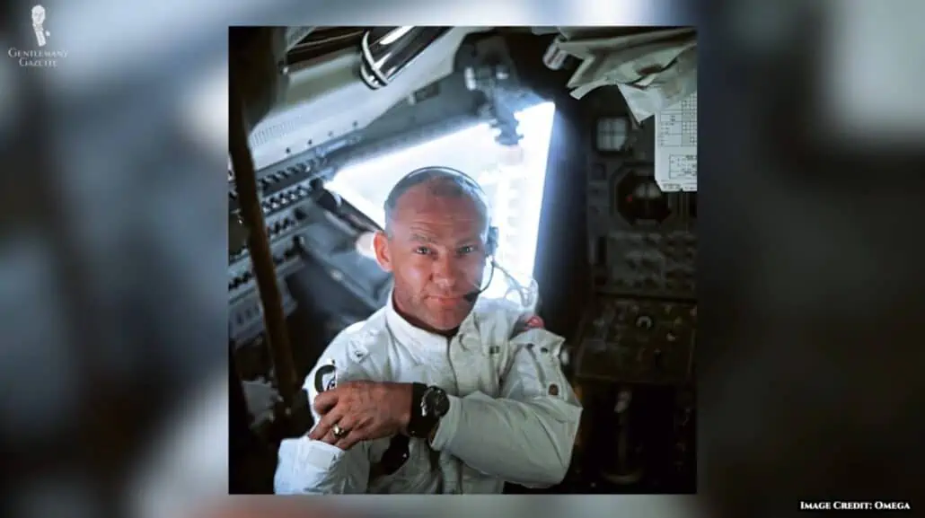 A photograph of an astronaut in a space capsule wearing an Omega watch.