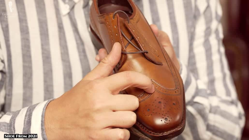Raphael showing the stitching on a 2021 Allen Edmonds shoe 1030x579 1