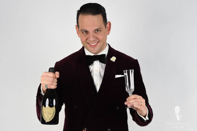 Raphael Schneider holds a bottle and glass of champagne
