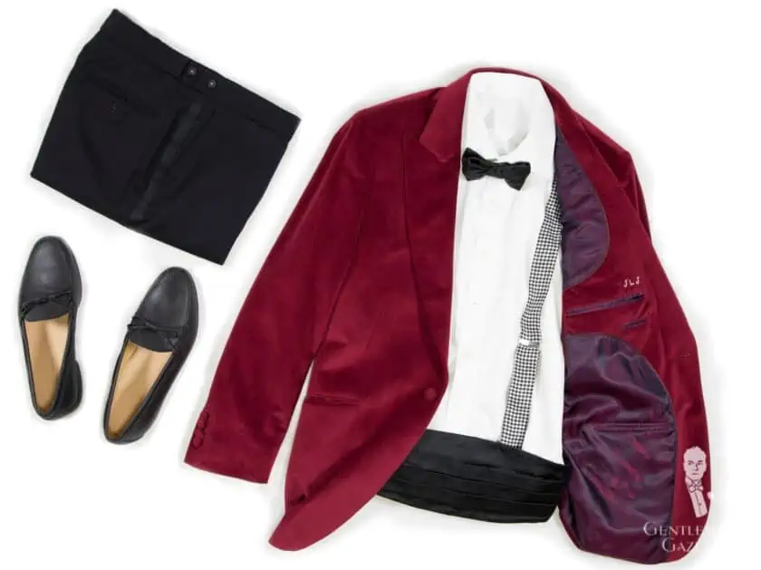 An example of a Black Tie alternative smoking jacket outfit with a dark red smoking jacket, black formal trousers, and formal slip-ons. 