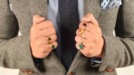 A photograph of a pair of hands with many rings on the fingers