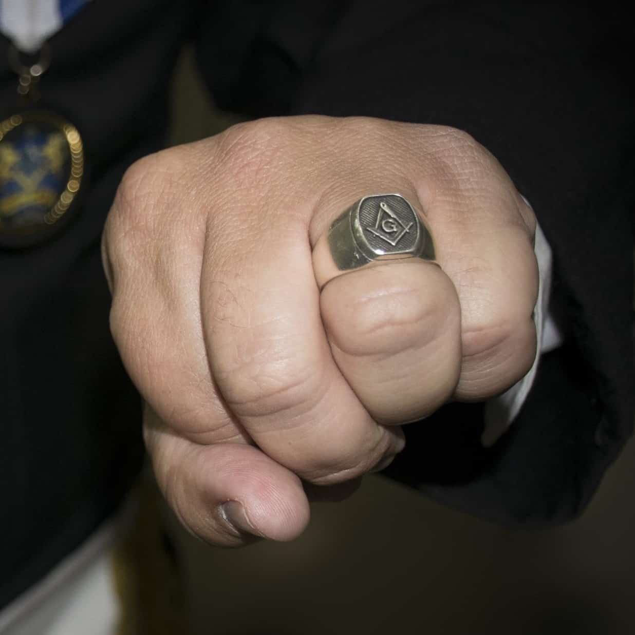 A photograph of a masonic ring worn on the ring finger