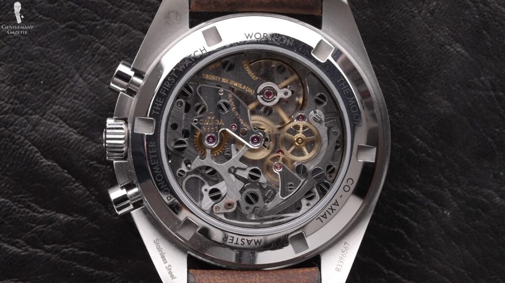 Cogs, wheels, and springs at the back of an Omega Speedmaster watch; this watch is powered by mechanical movements.
