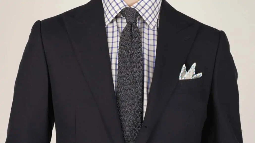 Preston wearing an open weave white pocket square that features a light blue X stitch