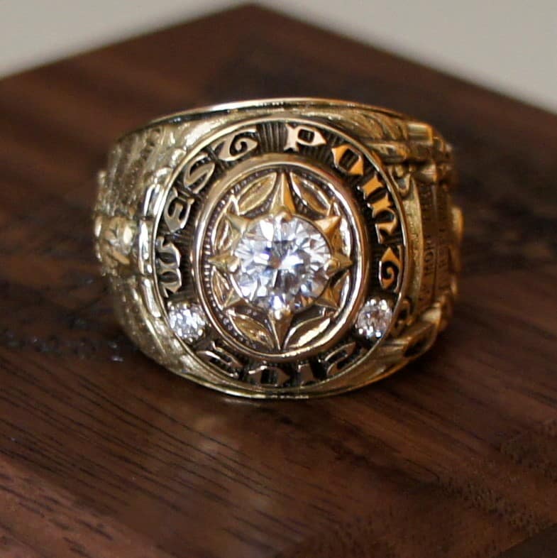 A large gold class ring with a clear stone