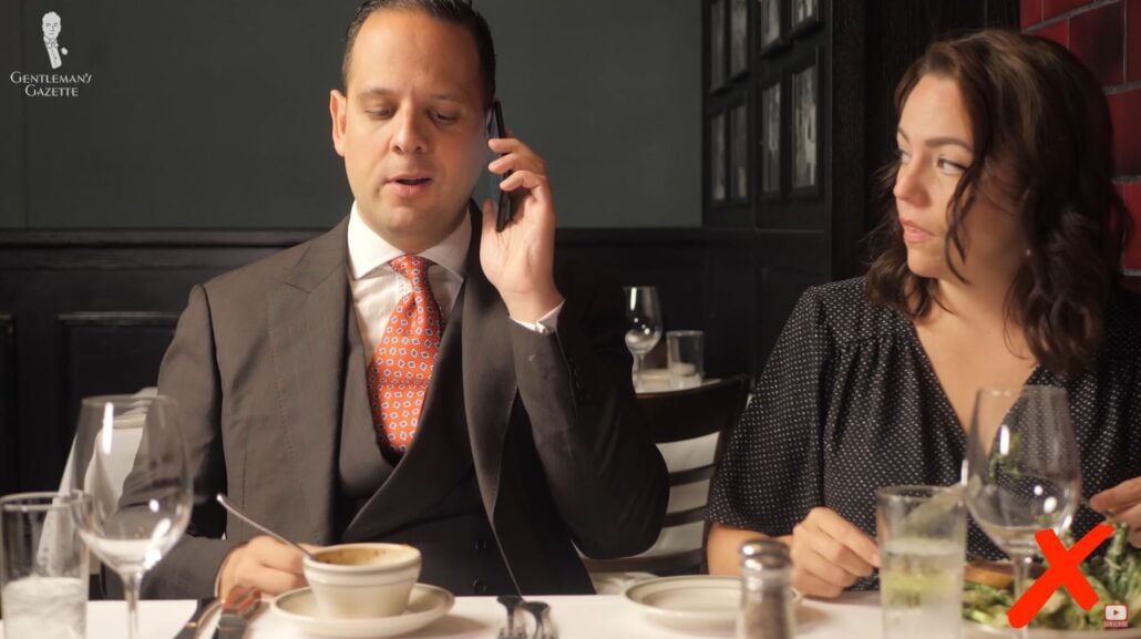 Phone It is rude to be on your phone while dining (Pictured: Orange Red Jacquard Woven Tie from Fort Belvedere)
