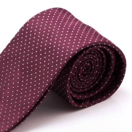 A photograph of a burgundy tie with white polka dots