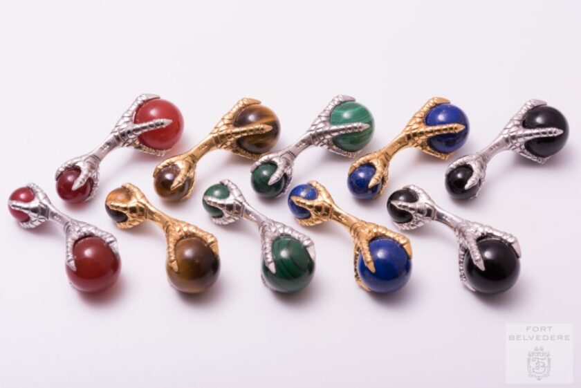 A collection of eagle claw cufflinks made from various metals and with various stones 