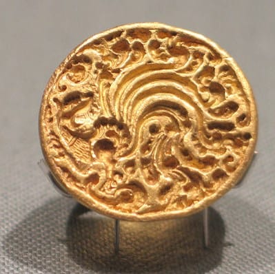 A photograph of a gold signet ring with a phoenix motif