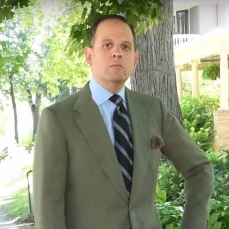 Raphael wearing a green suit jacket with a blue shirt