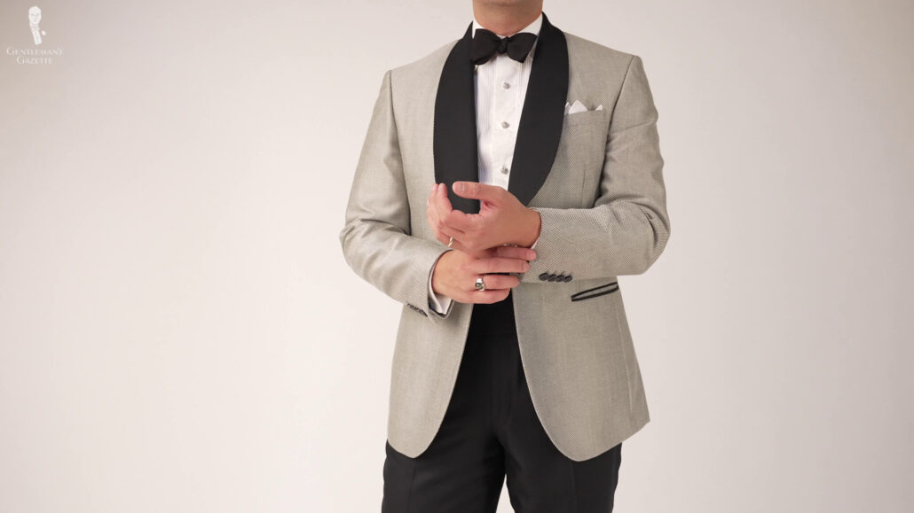 Raphael wearing a gray and black dinner jacket paired with a white shirt.
