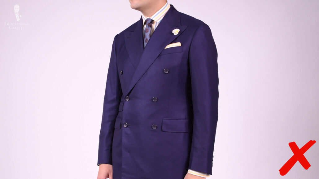 Raphael wearing a navy blue double-breasted suit.