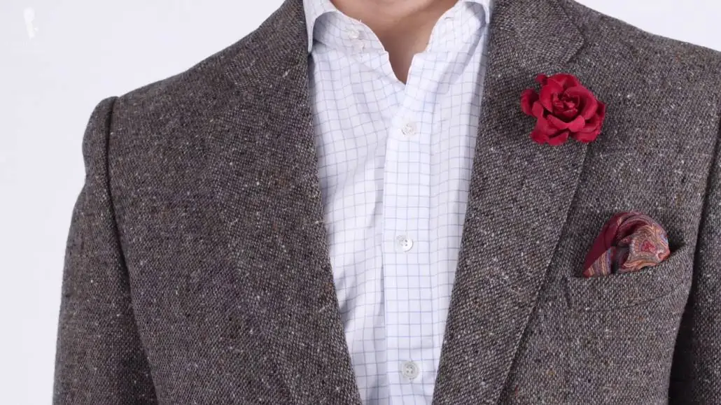Silk wool burgundy pocket square paired with a gray flannel jacket a checked shirt and a red rose boutonniere.
