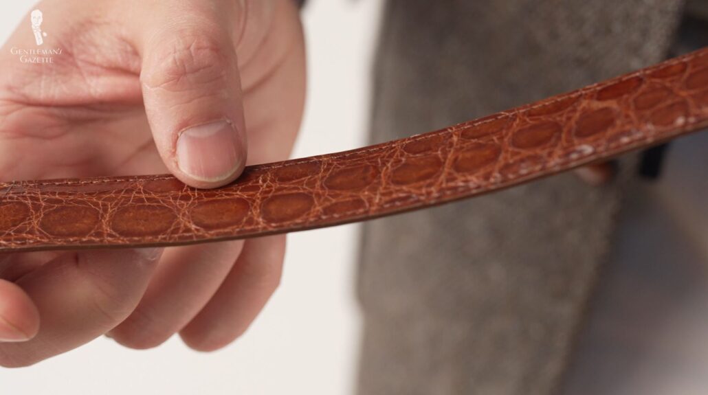 Raphael examines an alligator leather belt