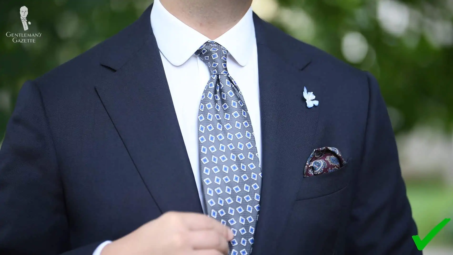 A blue suit worn with a battleship Gray Jacquard Woven Tie with Printed Light Blue and White Diamonds from Fort Belvedere