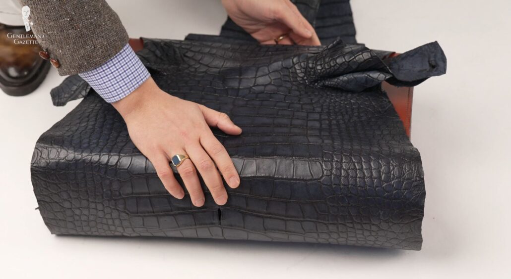 Raphael checks the fit of an alligator leather on a suitcase