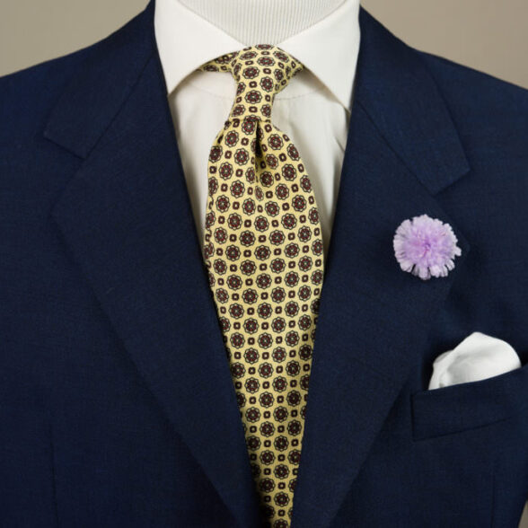 In this classic navy and yellow combination, the Purple Field Scabious Boutonniere adds a pop of color to the muted tie, shirt, and jacket.