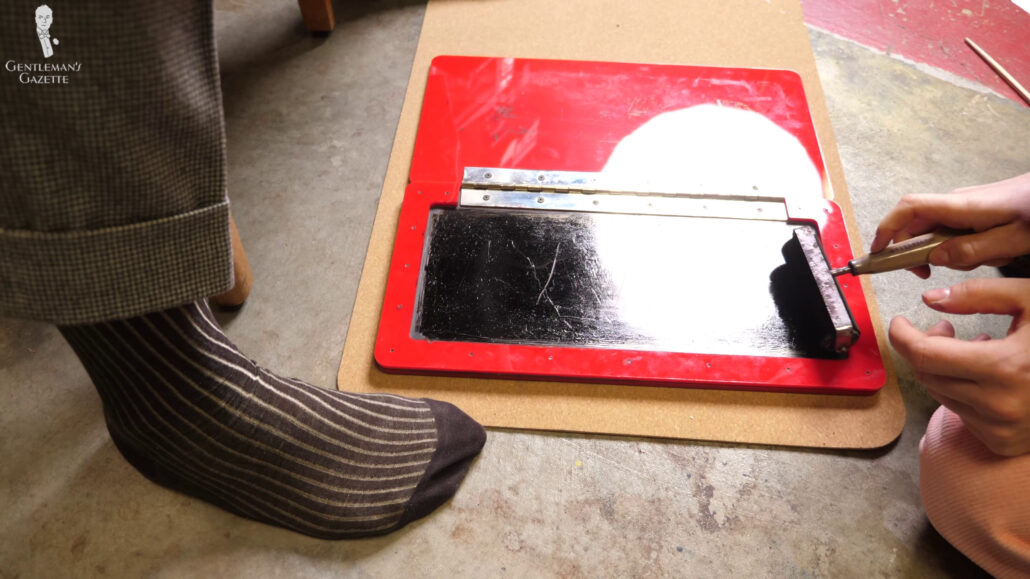 An old-school roller is used to distribute the ink evenly on the inside of the pad.