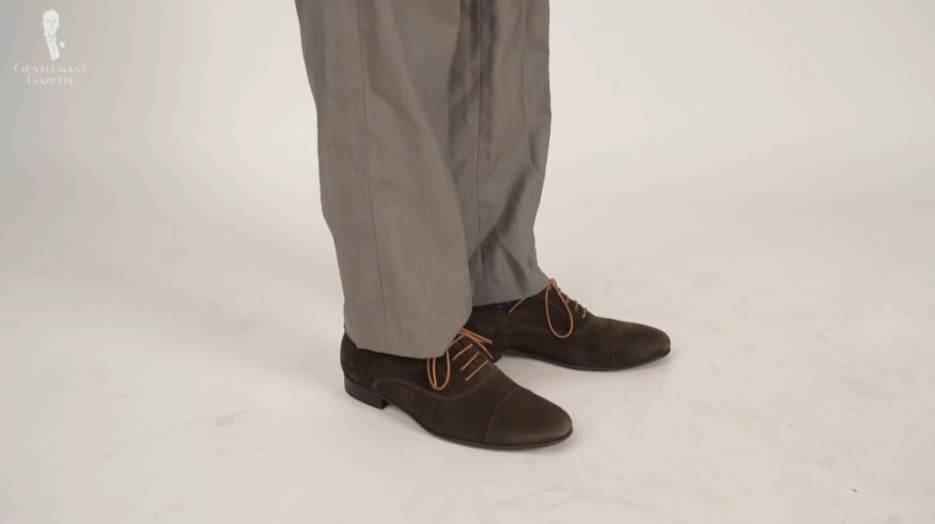 Preston's trousers in taupe color and his shoes are chocolate brown suede, cap-toed Oxfords from Undandy.