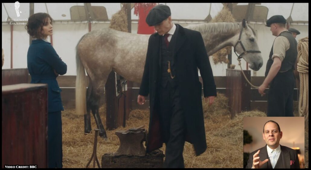 Tommy Shelby dons a newsboy cap, three-piece suit, Winchester shirt, single-breasted waistcoat with a pocket watch, a tie, and a long overcoat. [Image Credit: BBC]