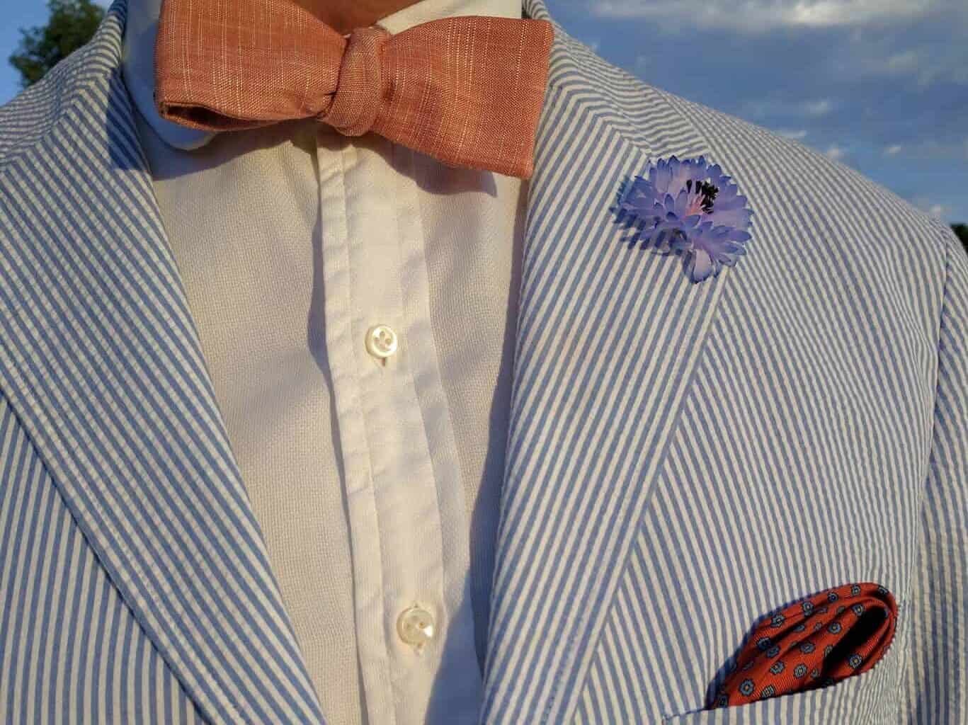 White Shirt with patch pocket seersucker suit, and orange and blue pocket square, bow tie and boutonniere by Fort Belvedere