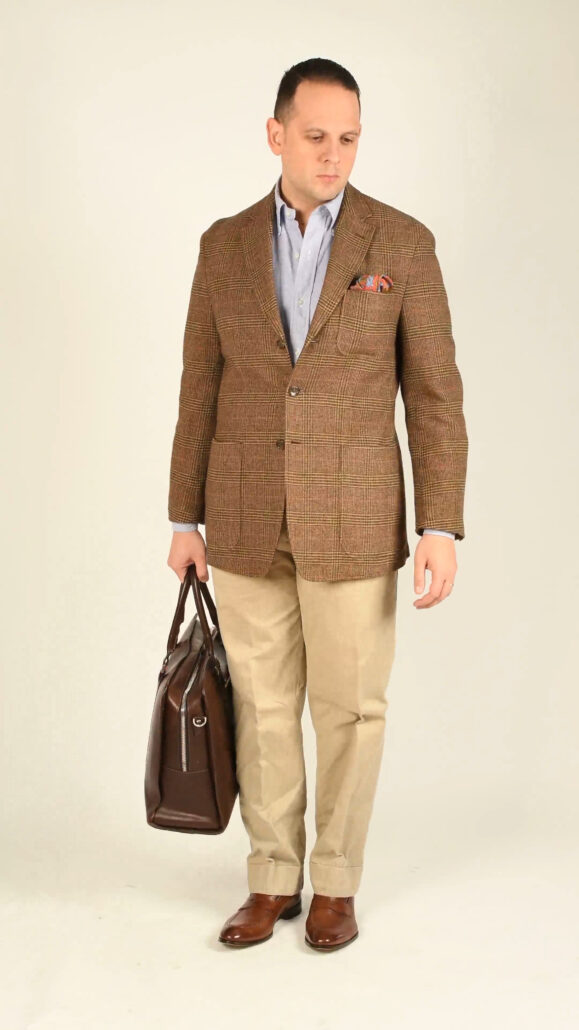 Tan loafers add to the rustic feel of this outfit, harmonizing well with the brown tweed jacket and khaki trousers