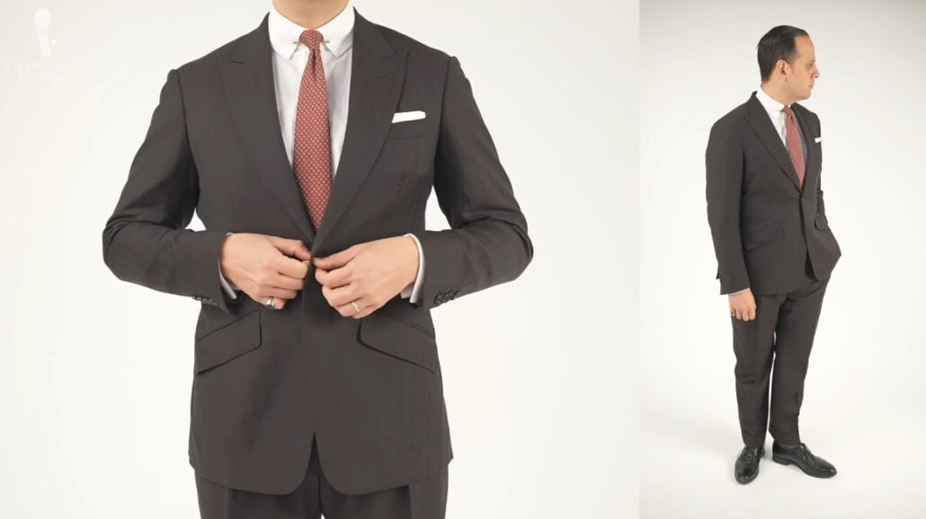 Raphael wearing a single-button dark business suit that has orange and red multi stripes.