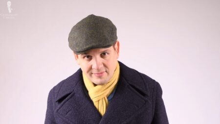 Raphael dons a flat cap with his winter wear (Pictured: Herringbone Cashmere Scarf in Mustard Yellow and Grey from Fort Belvedere)
