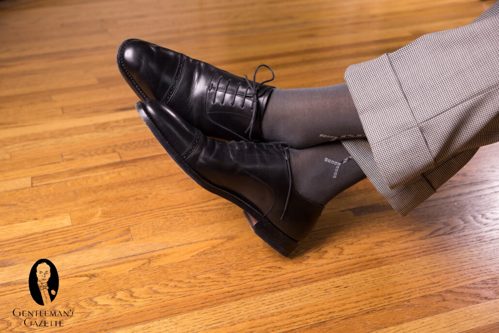Black semi brogue Oxford shoes with grey pants and socks