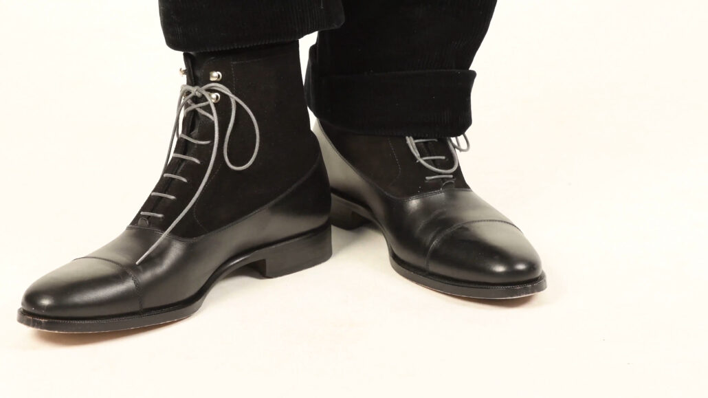 Raphael shows off a pair of Balmoral boots in black leather and suede with grey Fort Belvedere laces