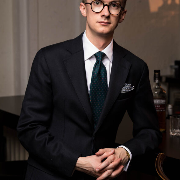 A photo of Jack wearing a navy suit with Fort Belvedere accessories